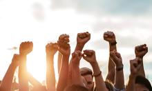 group of arms raised with fists