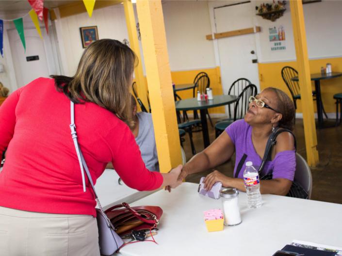 Austin housing authority meeting residents shaking hands