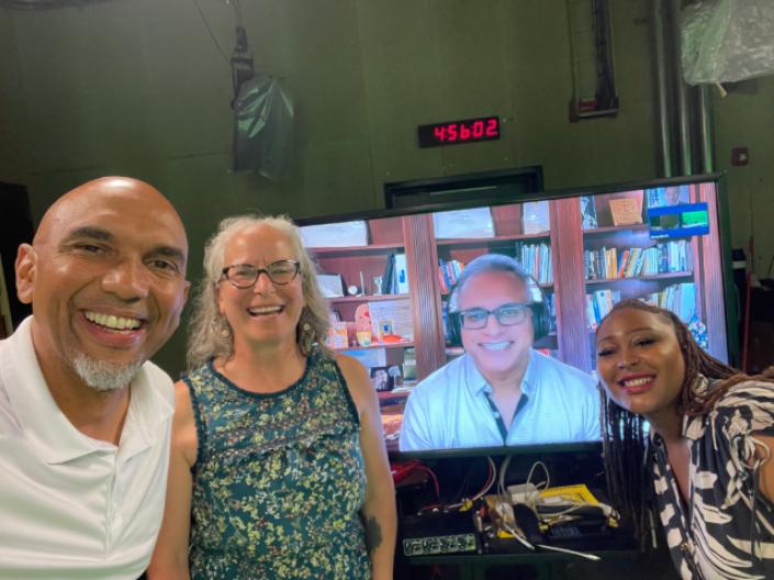 group of people smiling standing in front of computer monitor