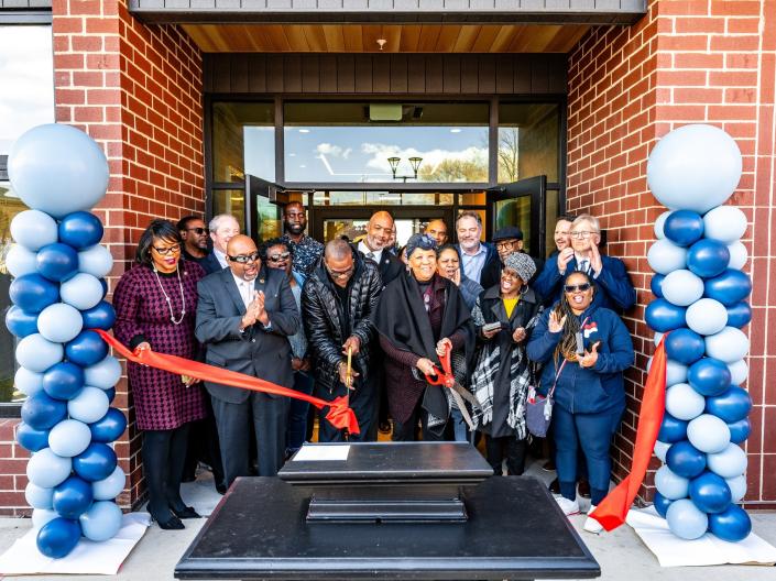Picture of a group of people cutting a ribbon during a ceremony