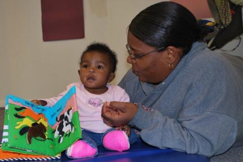 Woman and baby looking at book