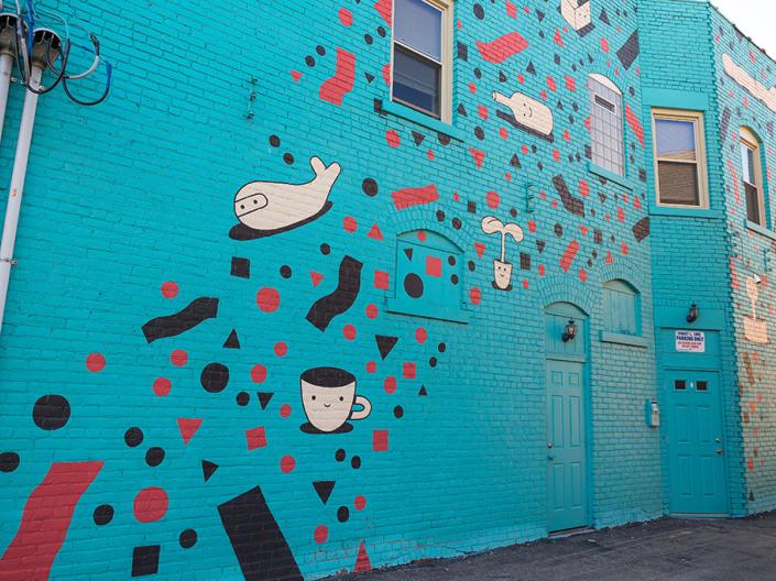 building mural with teal background, black and red squiggles