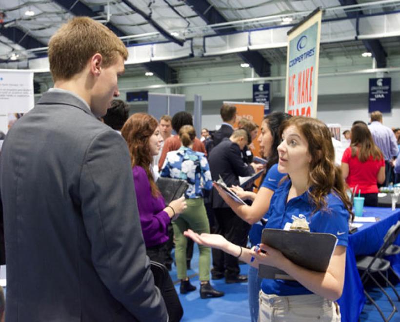 Student talking to a hiring manager at career fair