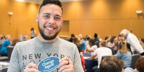 Student holding change agent sticker
