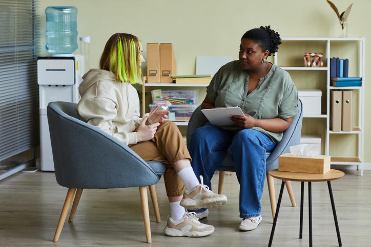 Social worker talking to a teenager in a session