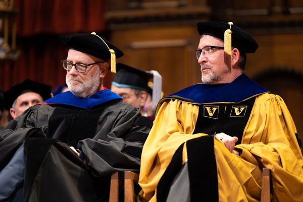 Dan Flannery and Rob Fischer clap during commencement 2023