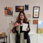 Gabriela Leskur holding a certificate and flowers