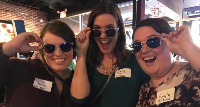 Young alums wearing sunglasses