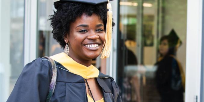 Woman in graduate gown smiling at camera