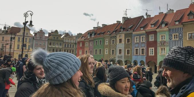 Study abroad group in front of old buildings in Poland