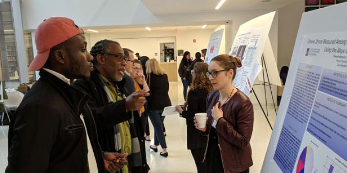 Mandel students and faculty learn about Collaborative Practice I projects during the showcase event in 2022 in the Mandel School lobby
