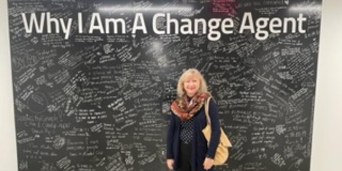 Agnieszka Naumiuk in front of the Mandel School's "Why I Am a Change Agent" sign