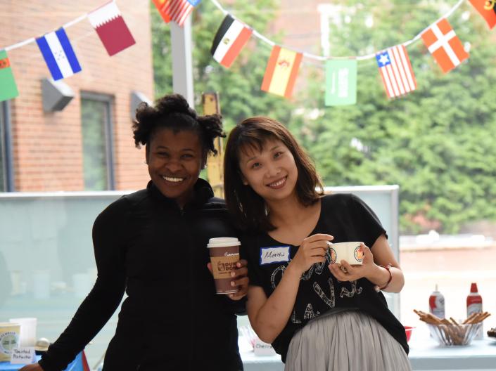 Two social work students pose in front of various country flags