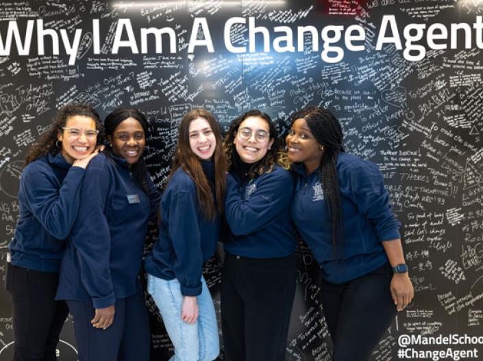 Five female students standing in front of the Why I Am A Change Agent sign