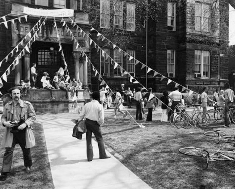 People standing outside Adelbert Hall with streamers coming down off it in a black and white picture