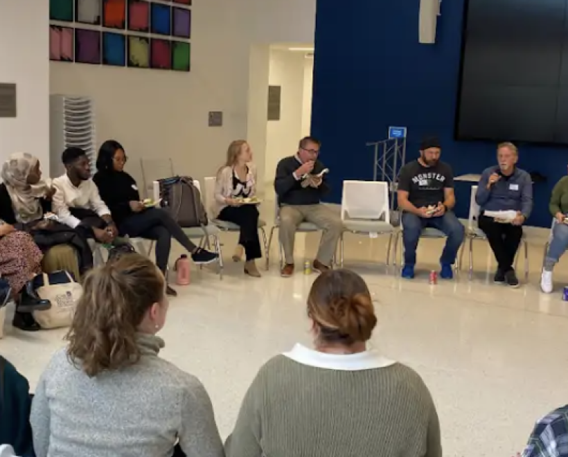 People sit in a circle in Noble Commons during 2024 Community Night