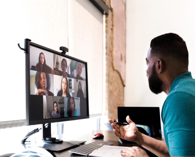 Man looks at a computer screen with others on Zoom