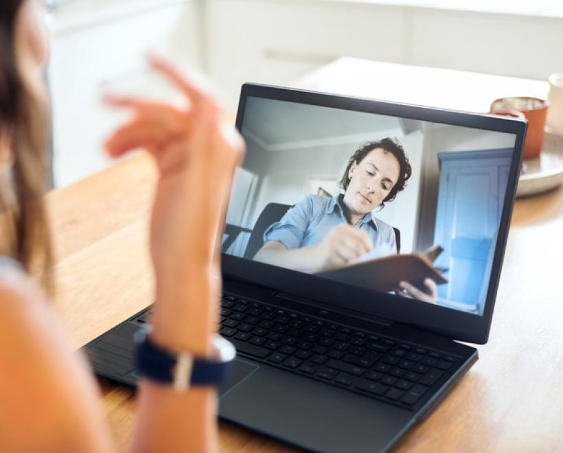 Person talks to someone on a screen who's taking notes