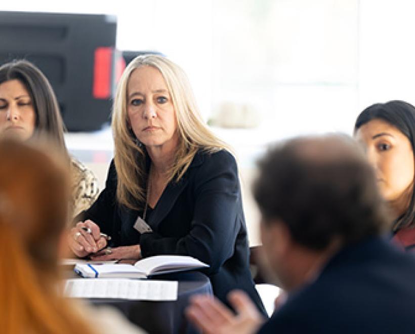 Student sitting at a table looking at a speaker