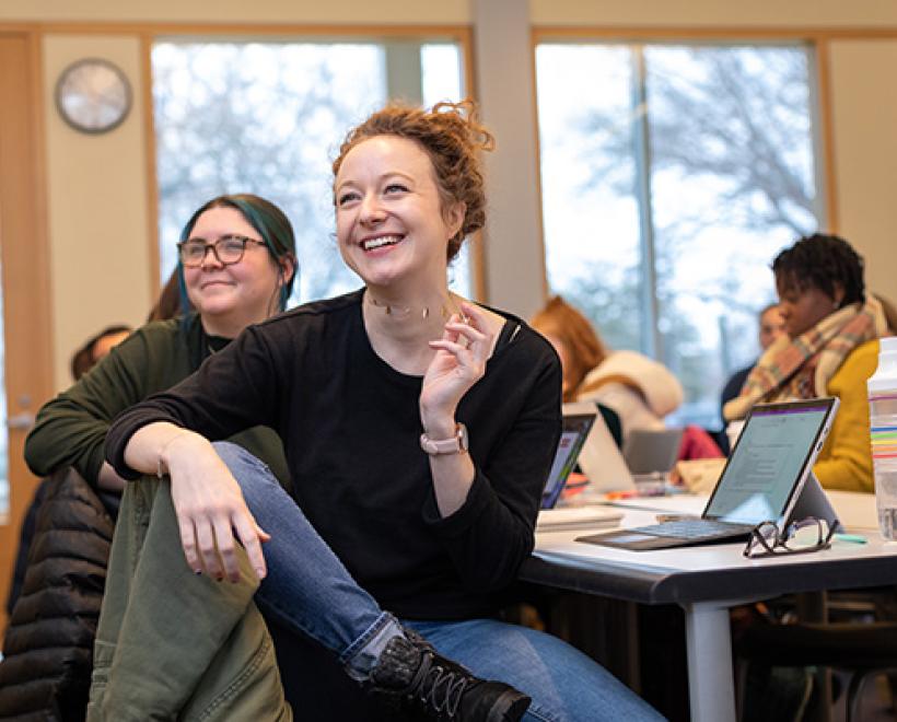 Two female smiling students in class