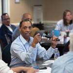 Scott Wilkes speaking into a microphone at a roundtable event