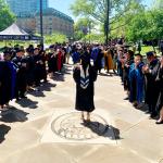 Grad walks out of the Maltz into the Mandel School clap-out celebration