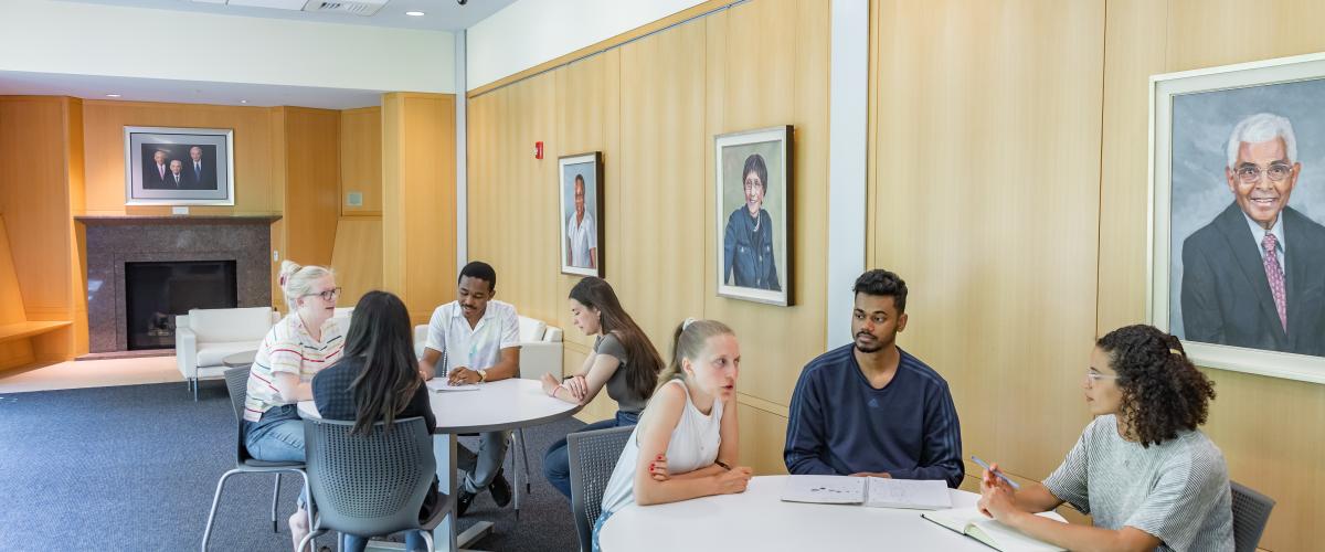 Group of students sitting at table having conversations
