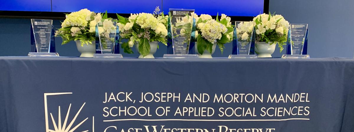 Alumni awards on blue Mandel School tablecloth with flowers