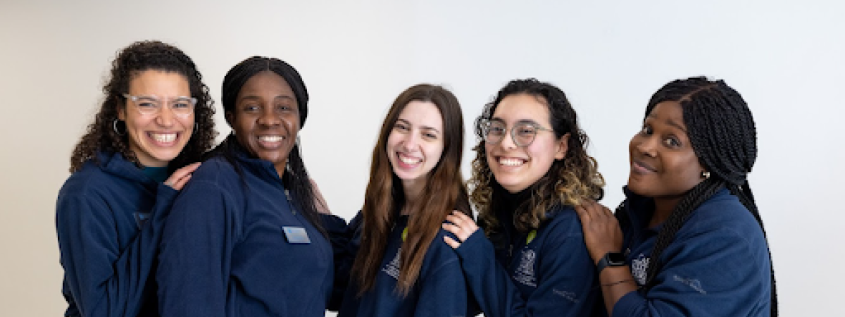 Five female presenting students wearing CWRU blue outfits