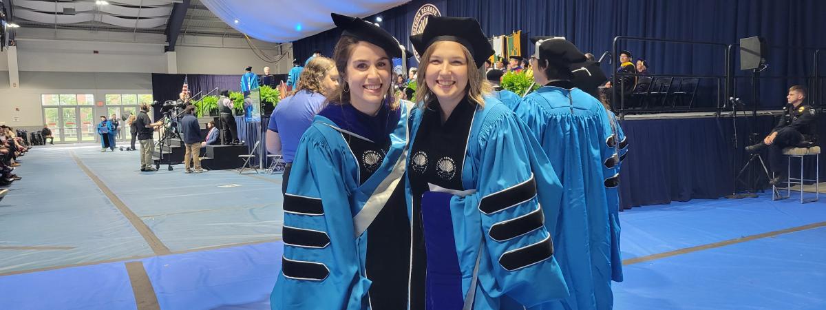 Graduating PhD students in cap and gown