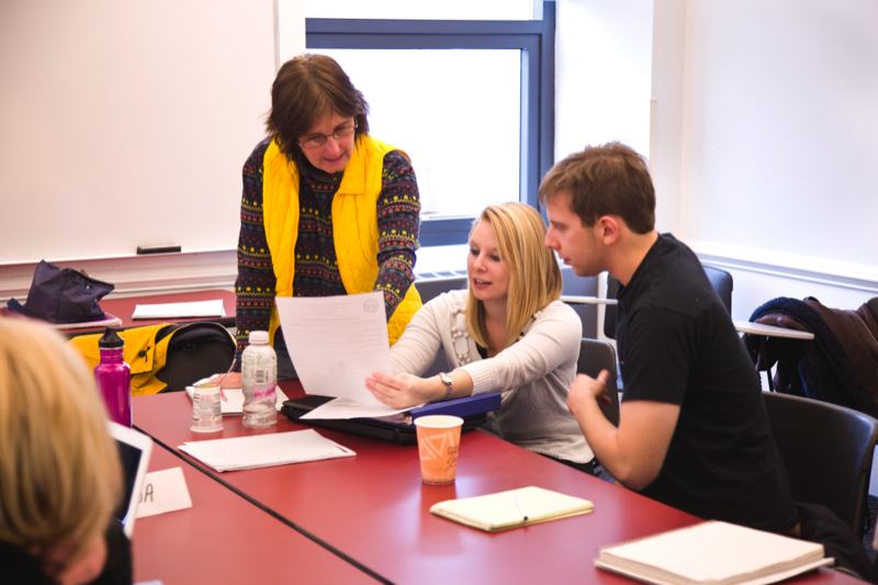 faculty member with students at table