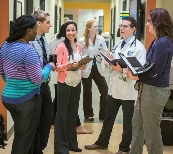 Students and professionals conversing in a hallway