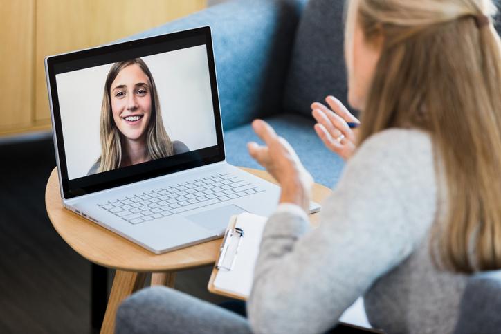 Woman chatting with another woman on a laptop