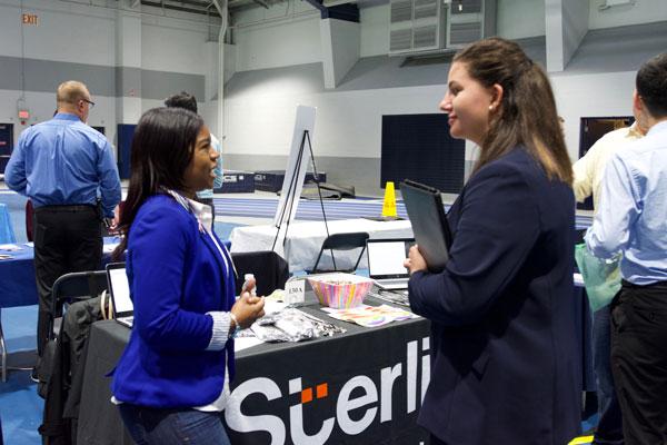 Student talking to a hiring manager at a career fair