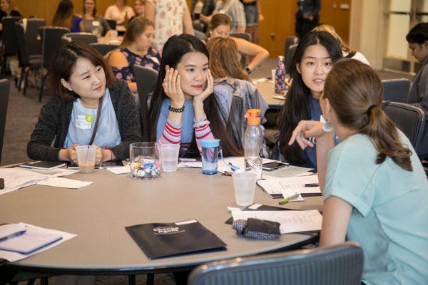 Four students sitting around a table talking