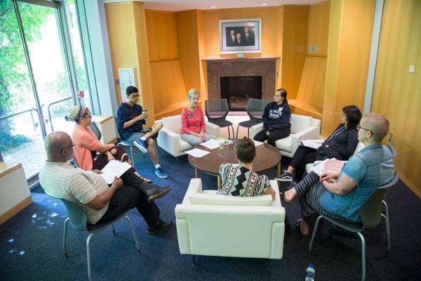 Group of students sitting in a circle of chairs in the Mandel Center lounge