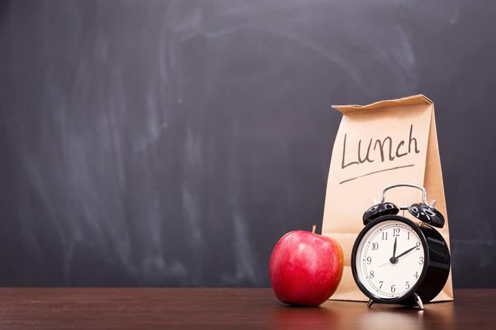 brown bag with apple and clock