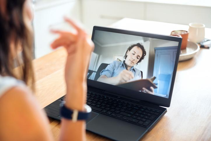 Person talks to someone on a screen who's taking notes
