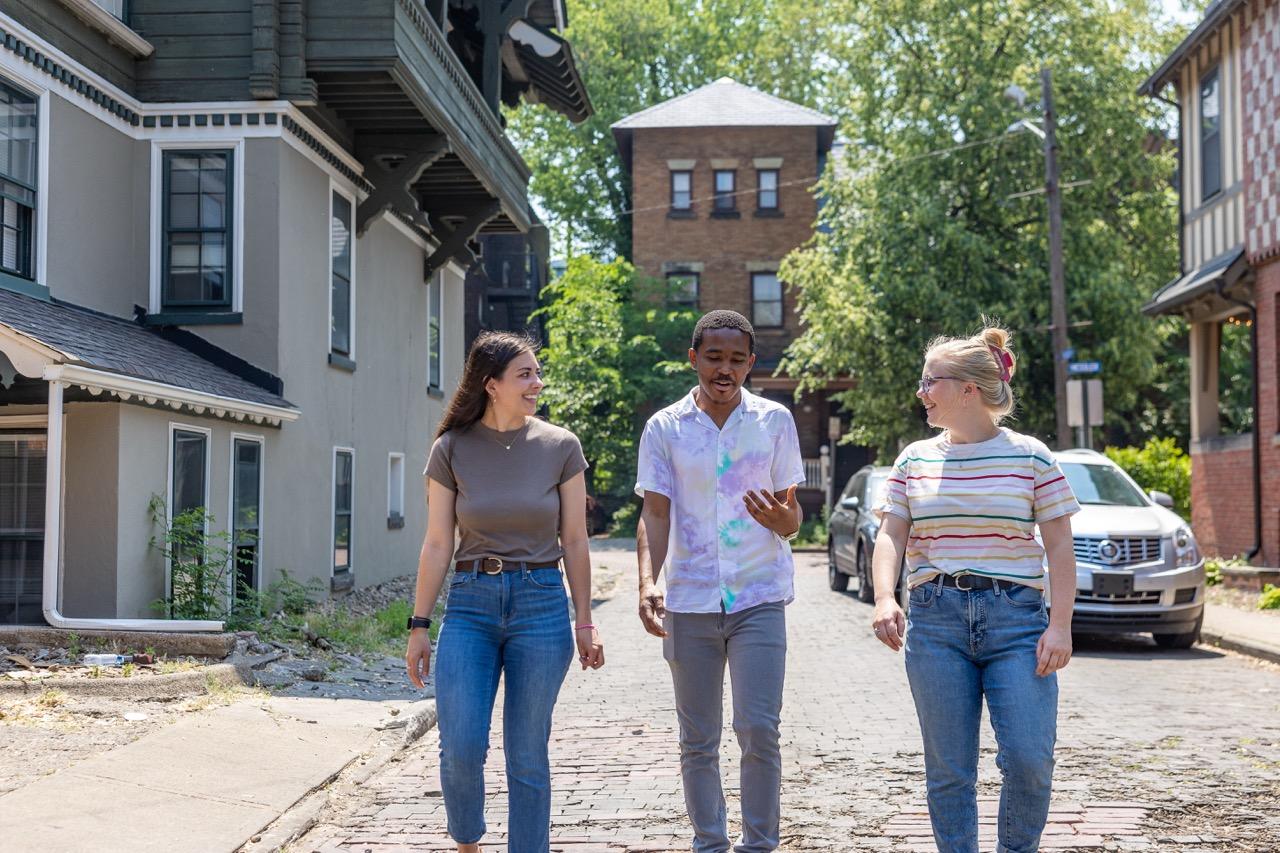 Group of three people walking down street