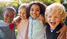 Group of diverse children hugging and laughing