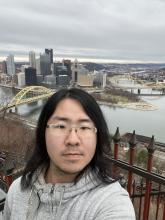 Peijian Wang selfie in front of Pittsburgh skyline