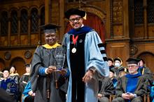 Ayowole Samuel Ajiboye and Dexter Voisin smile on stage at commencement