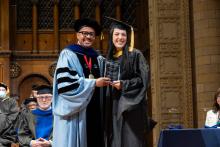 McKenna Uzelac and Dexter Voisin smile on stage at commencement