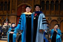 Diploma speaker Scott Ryan and Dexter Voisin smile on stage at commencement