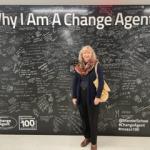 Agnieszka Naumiuk in front of the Mandel School's "Why I Am a Change Agent" sign