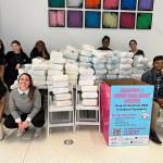 Students and staff stand next to the 2023 diaper donations