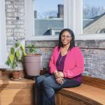 Lakecia Wild sits on a bench inside Magnolia Clubhouse