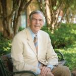 Terry Hokenstad sits on a bench outside the Mandel School