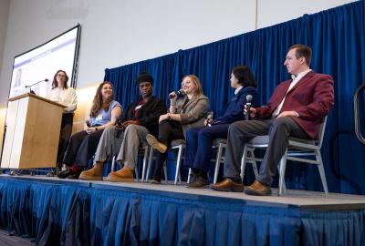 People sitting at a table in front of a projection screen