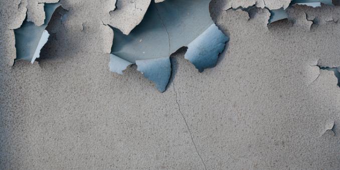 Gray lead paint peeling off a wall